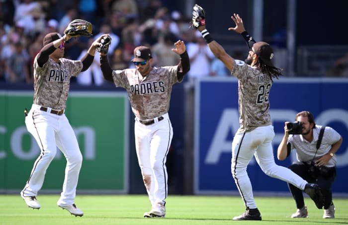 San Diego Padres left fielder Juan Soto (left), center fielder Trent Grisham (center) and right fielder Fernando Tatis jump up and put their hands in the air in celebration